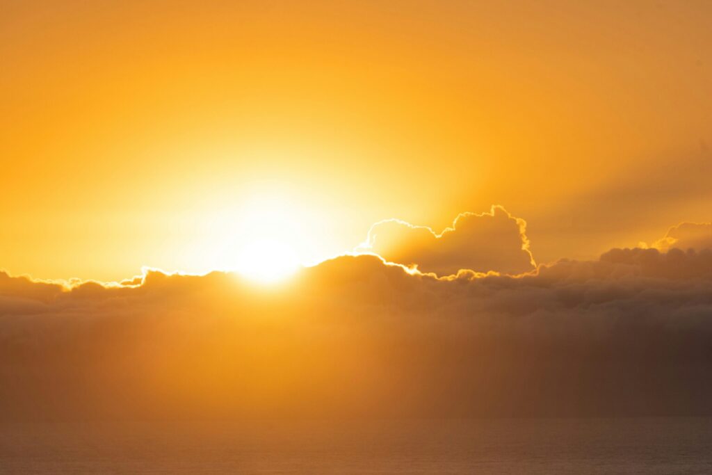 Breathtaking sunrise casting a warm glow over a cloudy horizon, perfect for nature lovers.